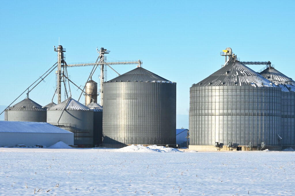 Sheet metal grain bins rise above an icy landscape