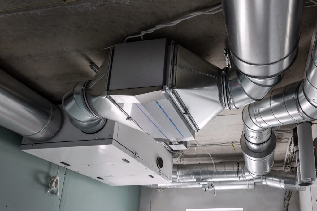 Custom fabricated HVAC ductwork runs along the ceiling of an industrial building.