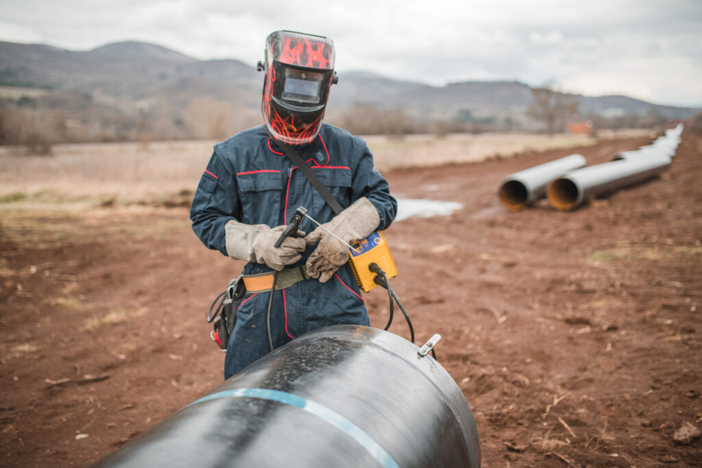 A welder works on a sheet metal fabrication project in the field